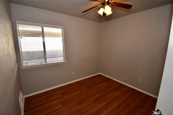 a view of wooden floor and chandelier fan in a room