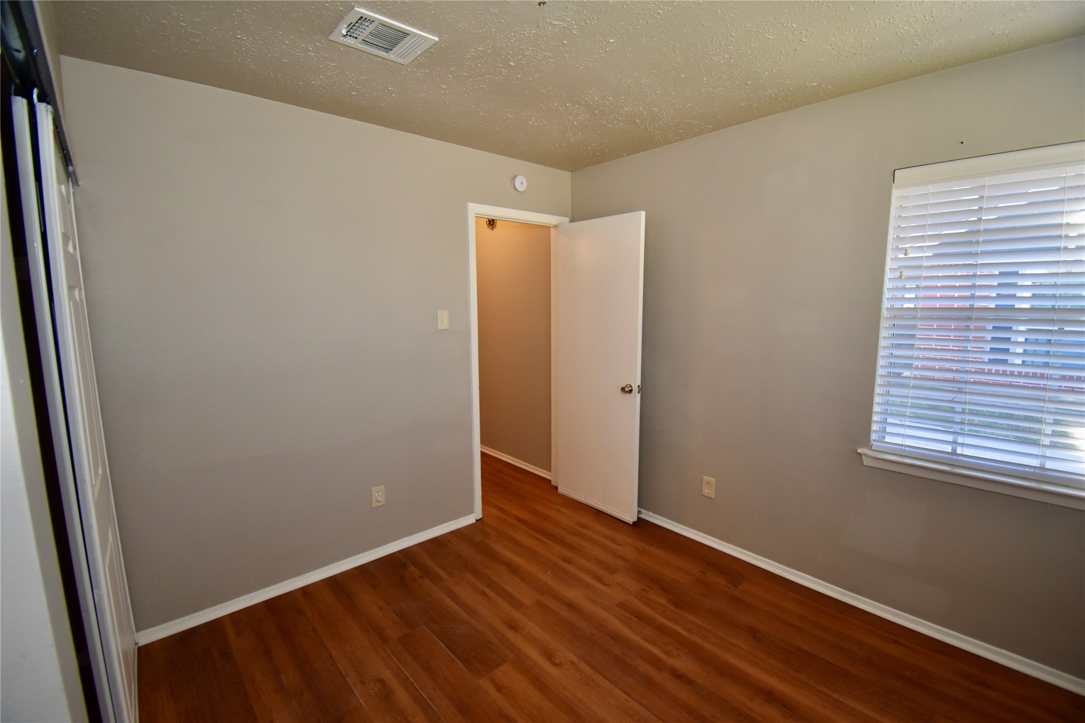 9231 Goodmeadow Drive Houston, TX 77064 - Photo 23 of 26 an empty room with wooden floor and windows