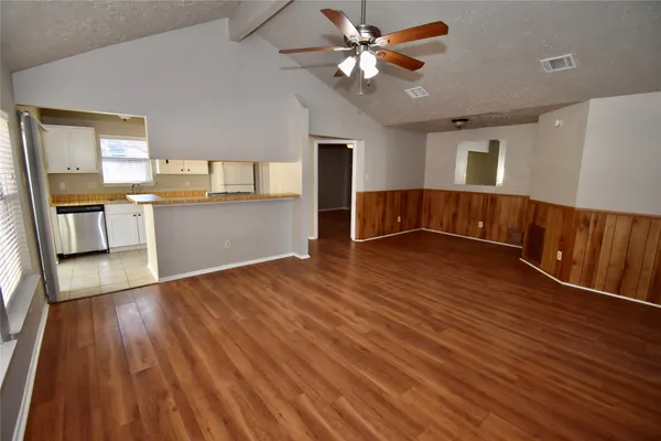 a view of a kitchen with wooden floor and a ceiling fan