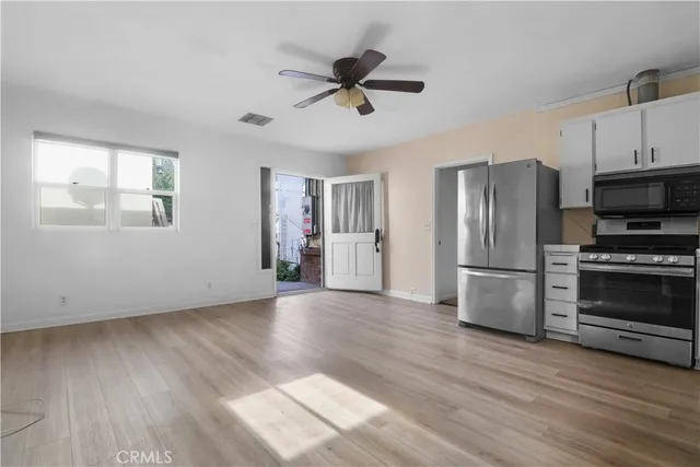 a view of kitchen with wooden floor electronic appliances and window