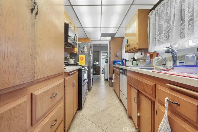 a kitchen with stainless steel appliances a sink counter space cabinets and a window