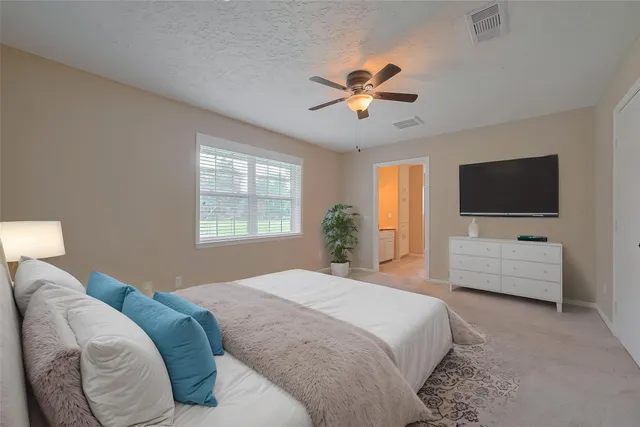 a bedroom with a large bed and a flat screen tv