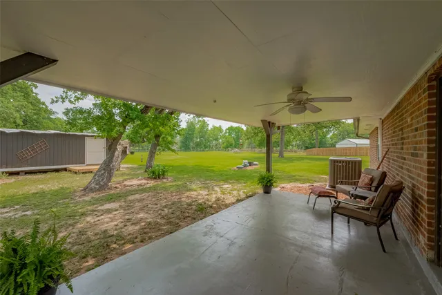 a view of a patio with a table chairs and a yard