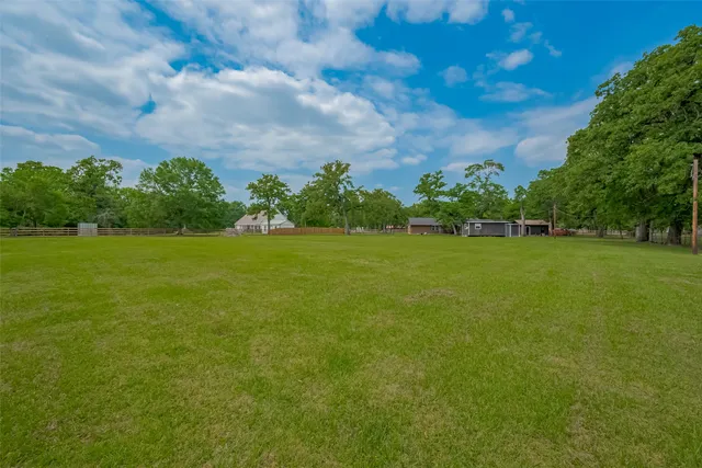 a view of a green field with wooden fence