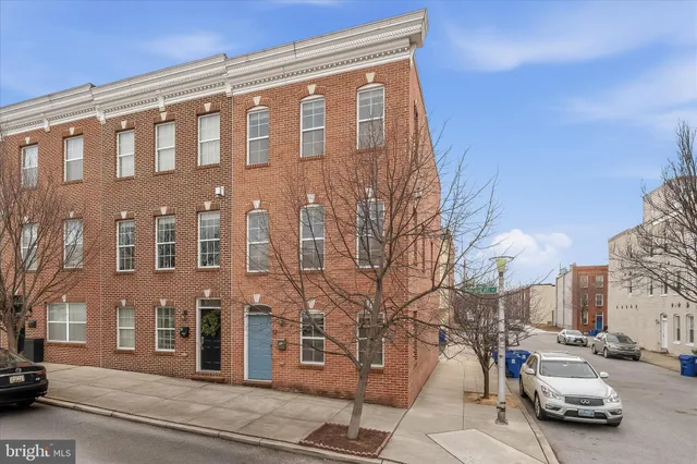 a city street lined with parked cars and buildings