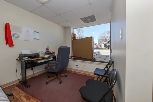 a view of a workspace with furniture and a window