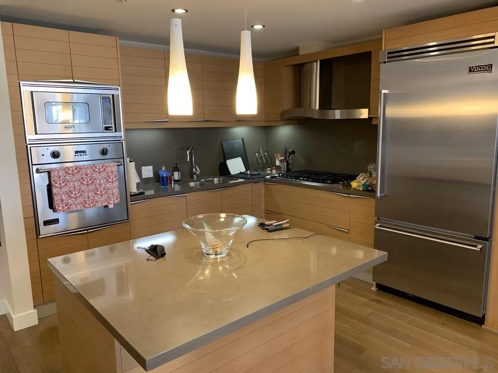 1325 Pacific Highway, Unit 1703 San Diego, CA 92101 - Photo 12 of 18 a room with stainless steel appliances granite countertop a sink and a refrigerator