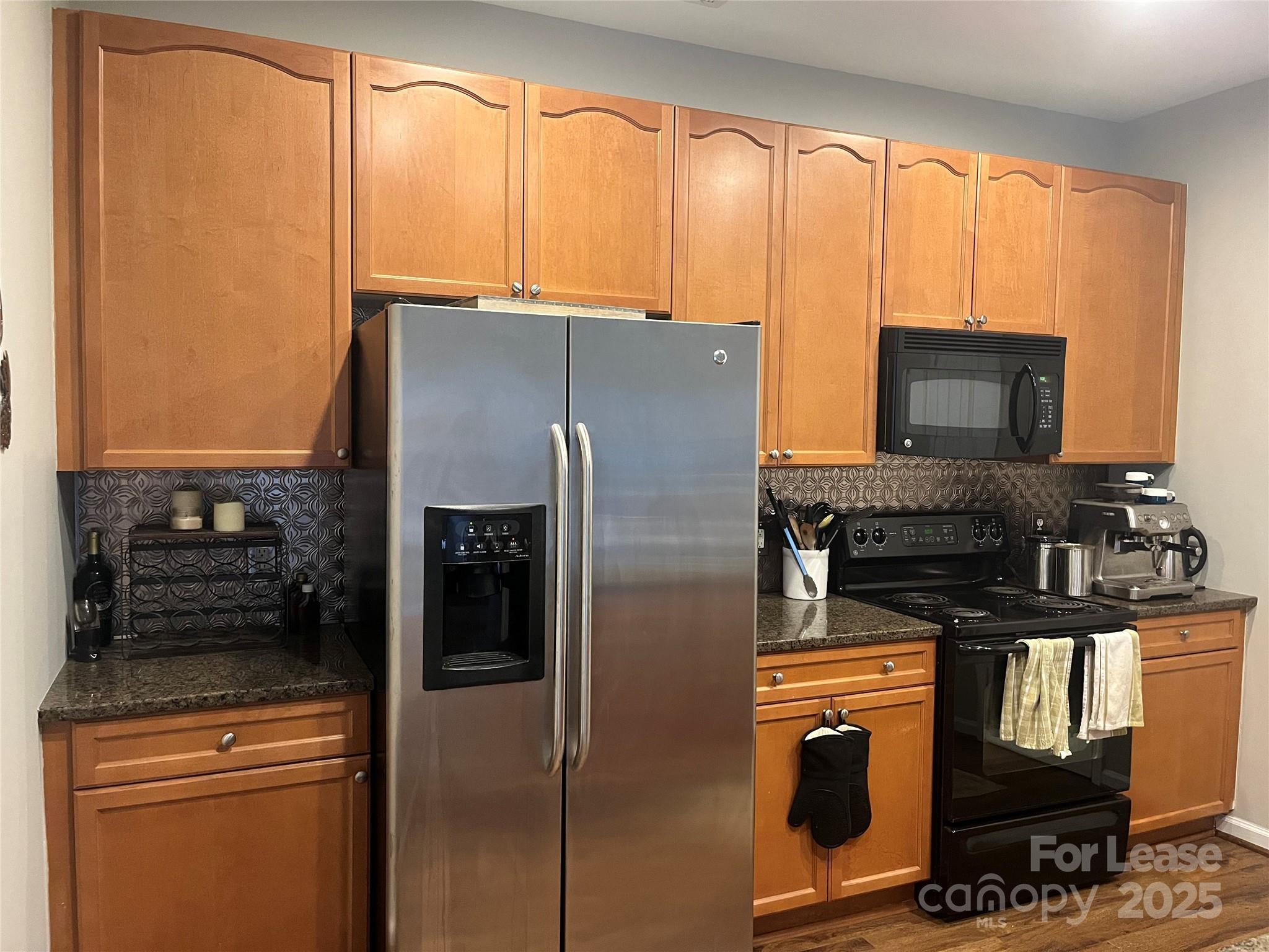 1131 Central Park Circle Davidson, NC 28036 - Photo 12 of 21 a kitchen with stainless steel appliances granite countertop a refrigerator a stove and a sink with large window