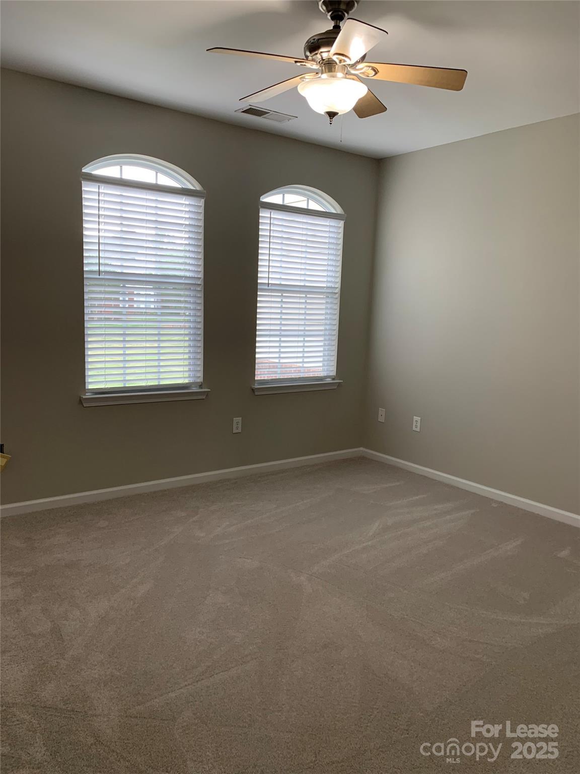 1131 Central Park Circle Davidson, NC 28036 - Photo 18 of 21 en empty room with windows and chandelier fan