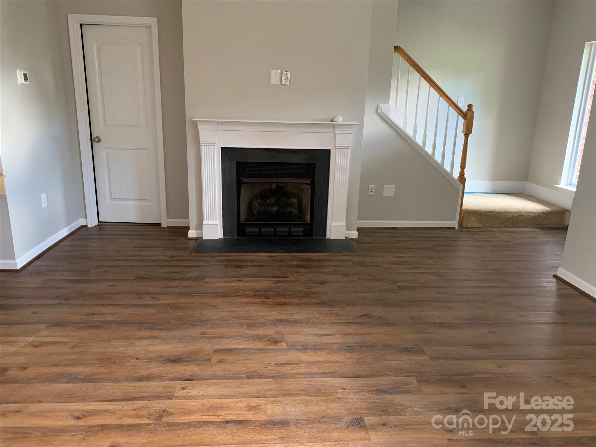 1131 Central Park Circle Davidson, NC 28036 - Photo 7 of 21 a view of an empty room with wooden floor and a window