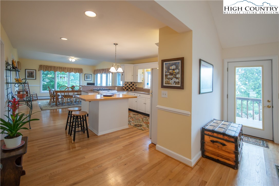 320 Misty Ridge Lane Blowing Rock, NC 28605 - Photo 12 of 46 a kitchen with stainless steel appliances granite countertop a refrigerator a stove top oven a dining table and chairs with wooden floor