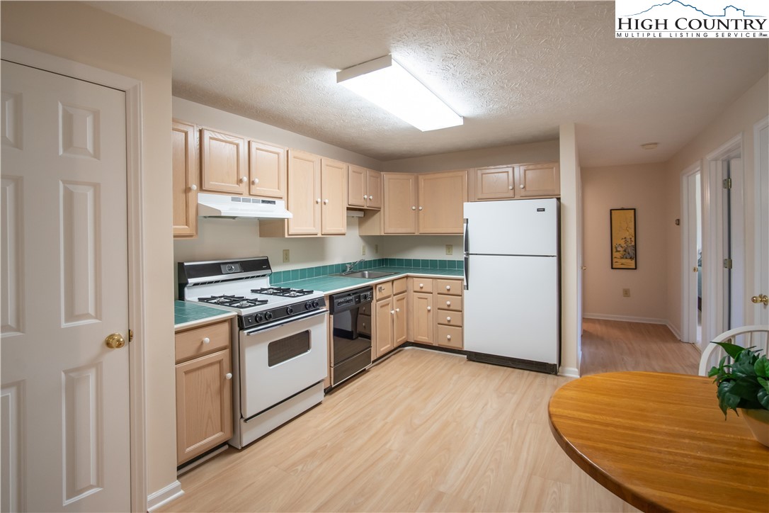 320 Misty Ridge Lane Blowing Rock, NC 28605 - Photo 37 of 46 a kitchen with a refrigerator a stove and wooden floor