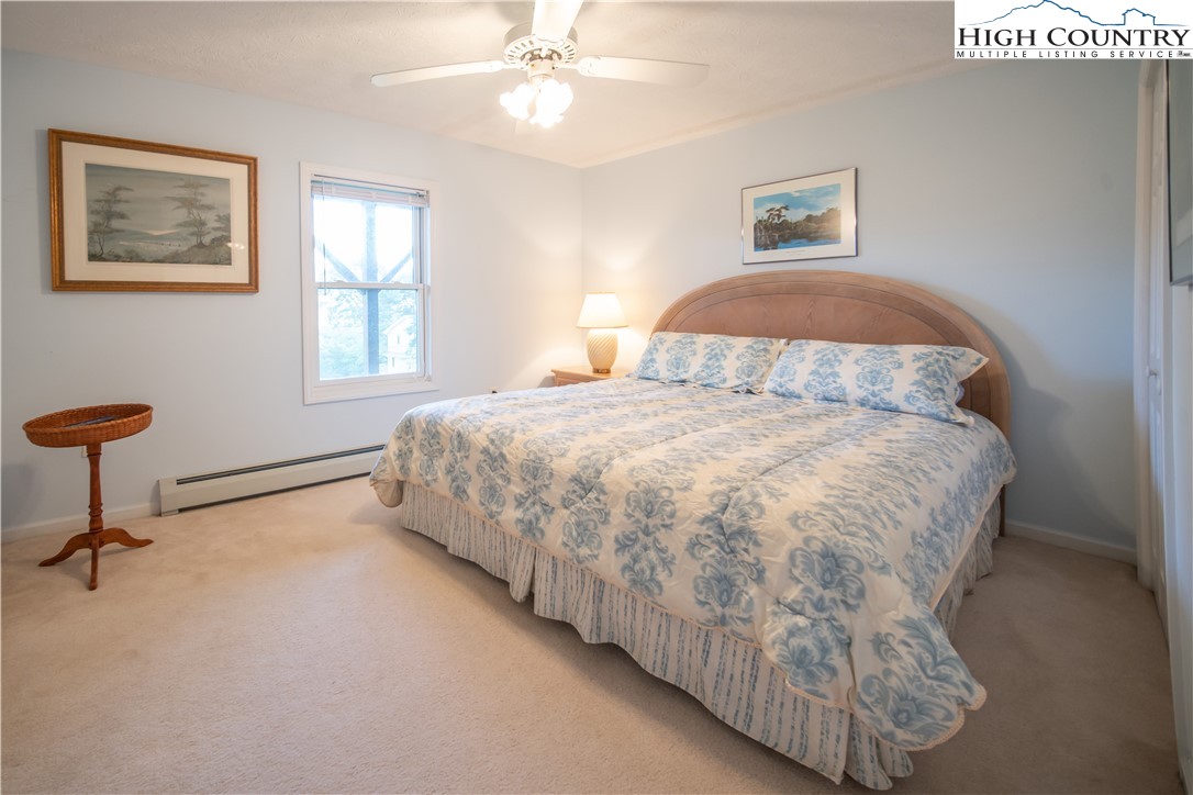 320 Misty Ridge Lane Blowing Rock, NC 28605 - Photo 38 of 46 a bedroom with a bed and a chandelier