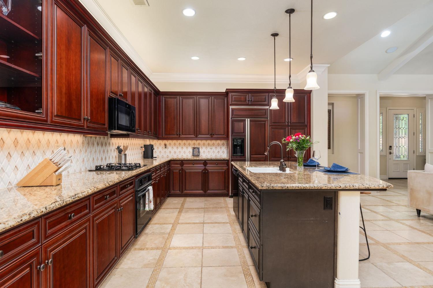 3545 Barclay Square Clovis, CA 93619 - Photo 11 of 31 a kitchen with stainless steel appliances granite countertop a stove a sink dishwasher and a refrigerator with wooden cabinets