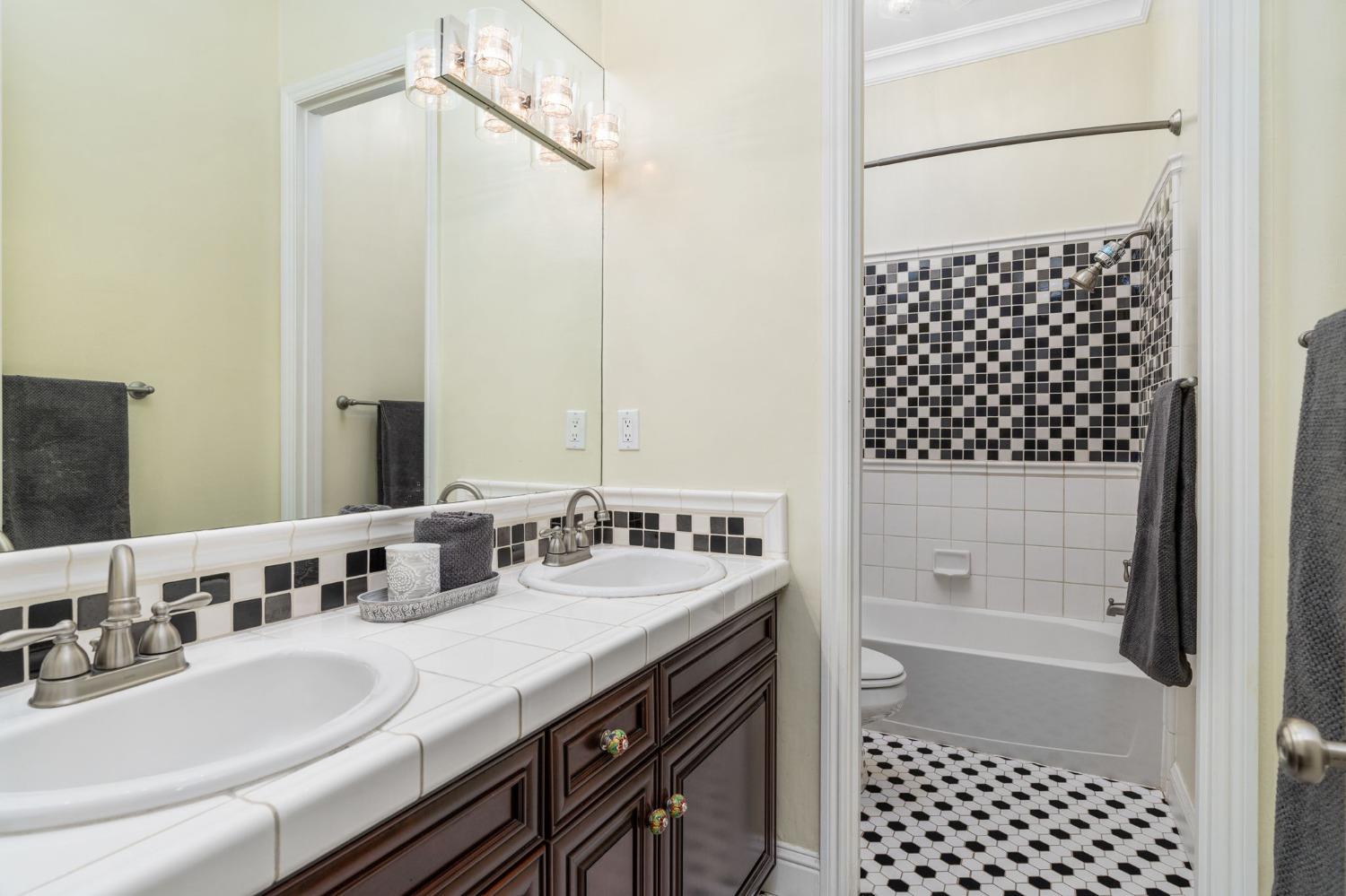 3545 Barclay Square Clovis, CA 93619 - Photo 16 of 31 a bathroom with a double vanity sink a mirror and a bathtub