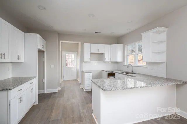 a kitchen with granite countertop white cabinets and white appliances