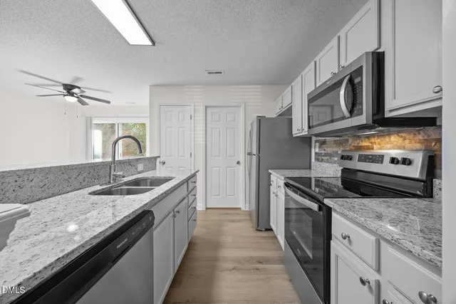 a kitchen with stainless steel appliances granite countertop a sink stove and refrigerator