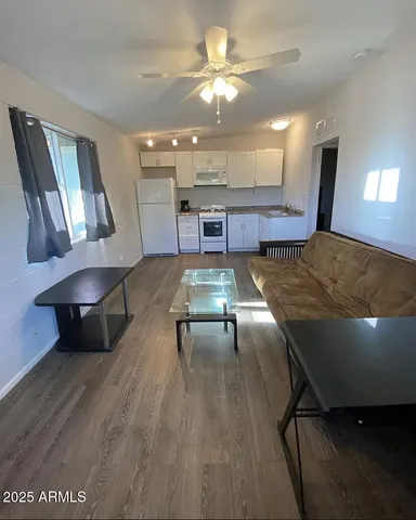a living room with dining room and wooden floor
