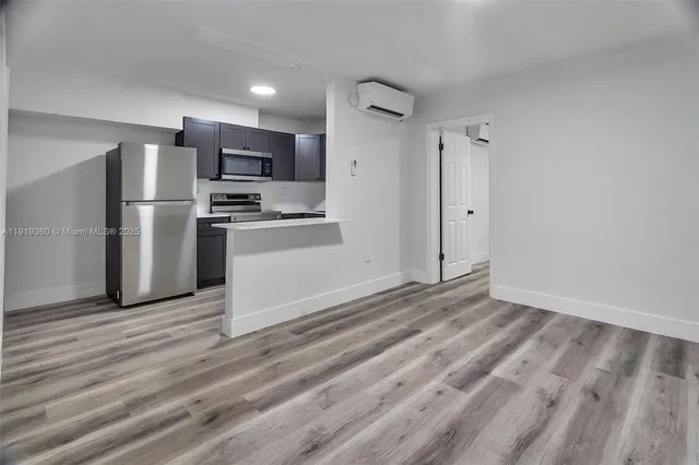 a view of a kitchen with wooden floor and electronic appliances