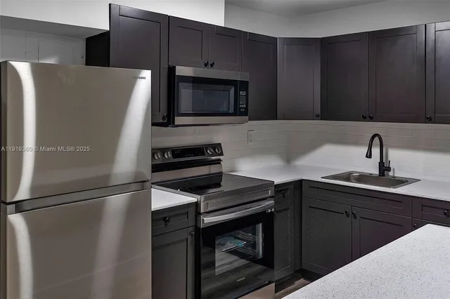 a kitchen with a refrigerator sink and cabinets
