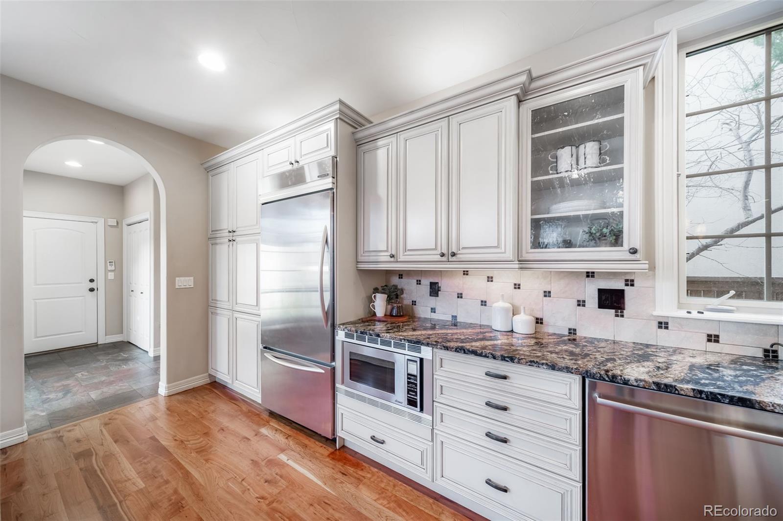 1425 South Elizabeth Street Denver, CO 80210 - Photo 11 of 50 a kitchen with granite countertop white cabinets and stainless steel appliances