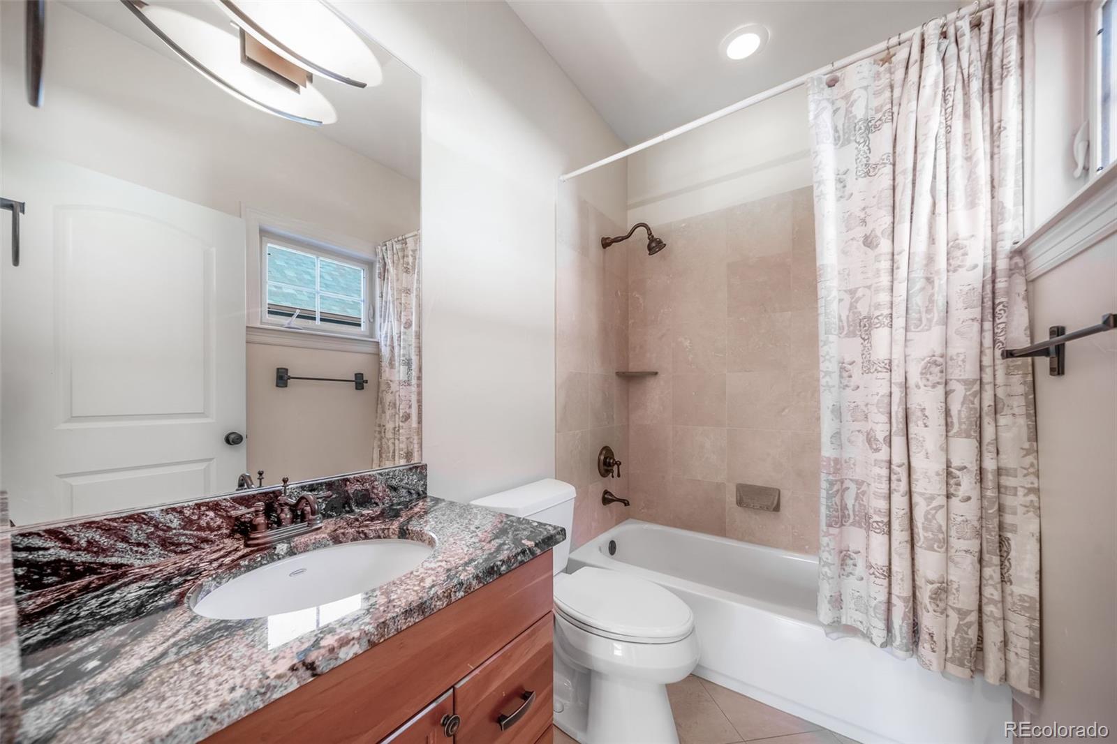 1425 South Elizabeth Street Denver, CO 80210 - Photo 23 of 50 a bathroom with a granite countertop sink toilet mirror and shower