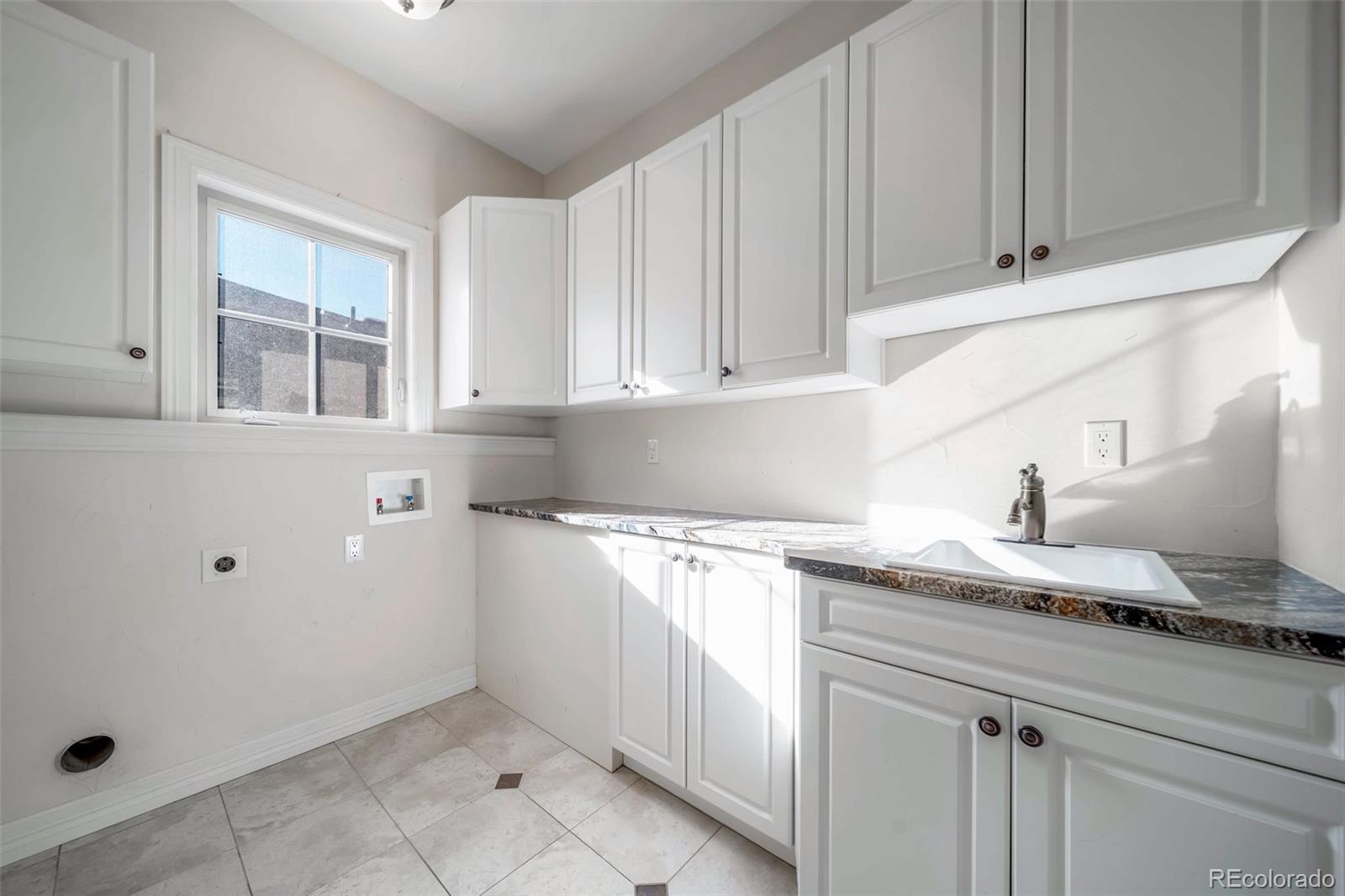 1425 South Elizabeth Street Denver, CO 80210 - Photo 32 of 50 a kitchen with granite countertop white cabinets and a sink