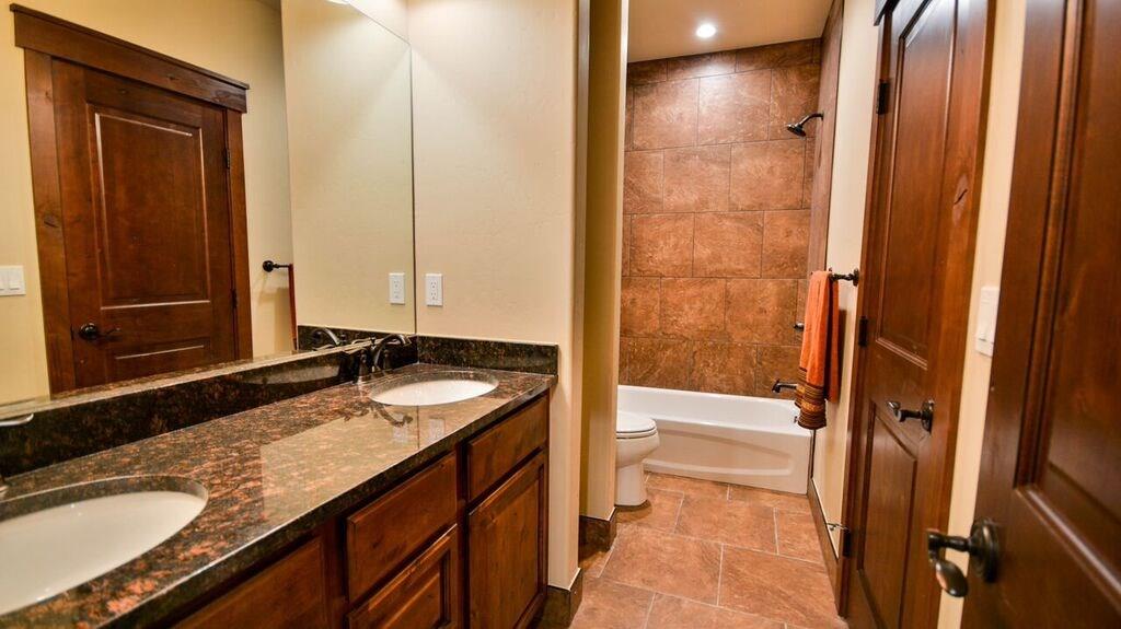 698 Independence Road, Unit 7A Keystone, CO 80435 - Photo 15 of 25 a bathroom with a granite countertop sink a mirror and a bathtub