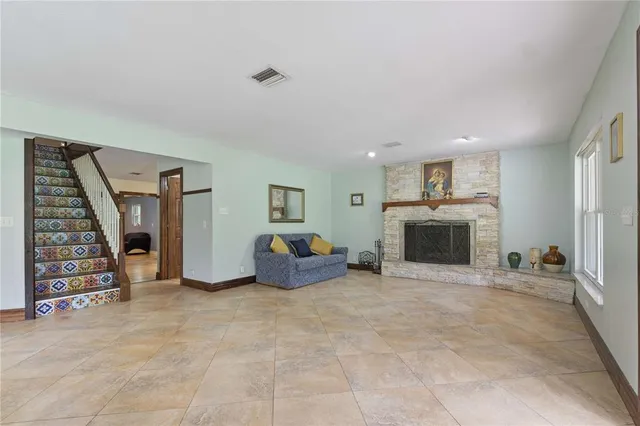a view of an empty room with fire place and a window