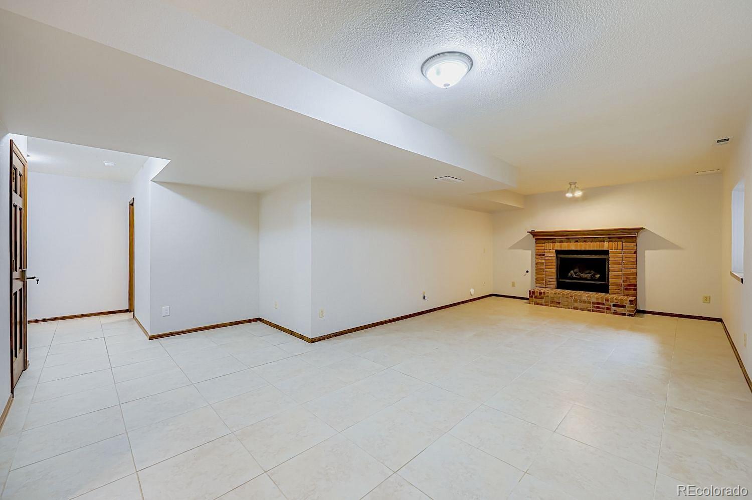 5825 Wilson Road Colorado Springs, CO 80919 - Photo 33 of 50 an empty room with furniture and a fireplace