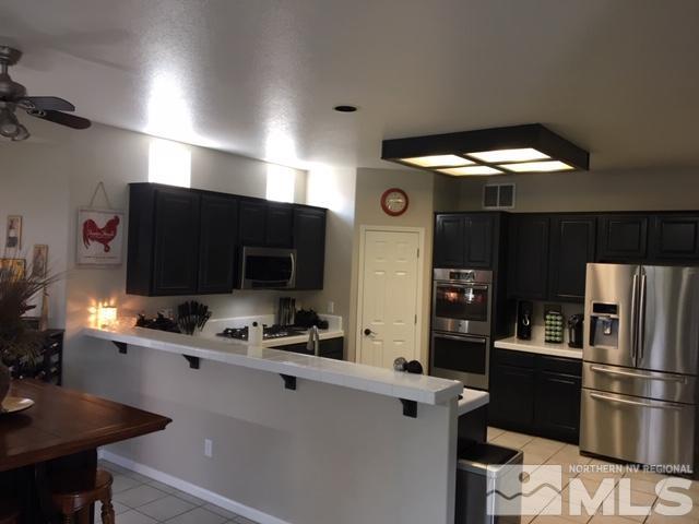 9970 Moccasin Court Reno, NV 89521 - Photo 2 of 6 a kitchen with a refrigerator and a stove top oven