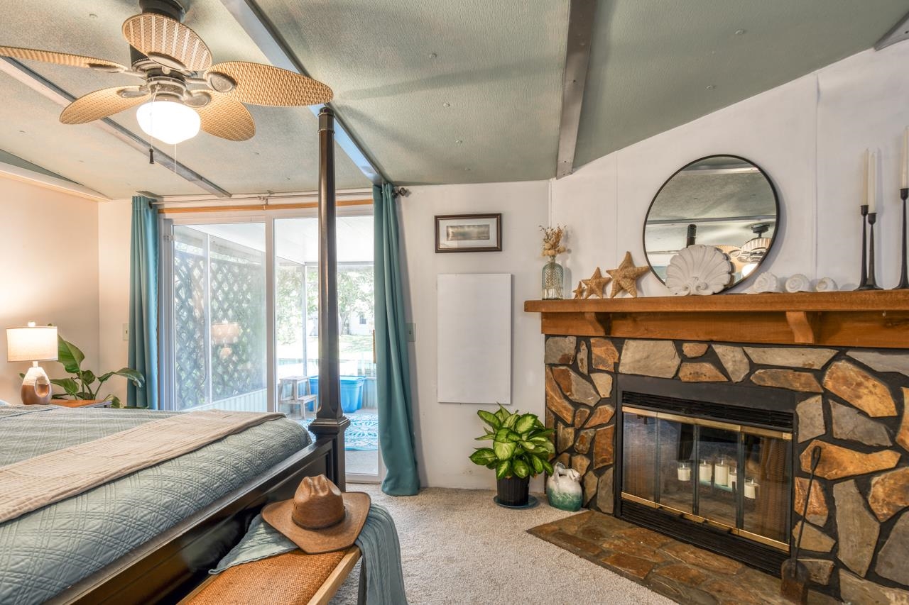 231 Hildago Road St. Augustine, FL 32080 - Photo 30 of 49 a living room with furniture a fireplace and a floor to ceiling window