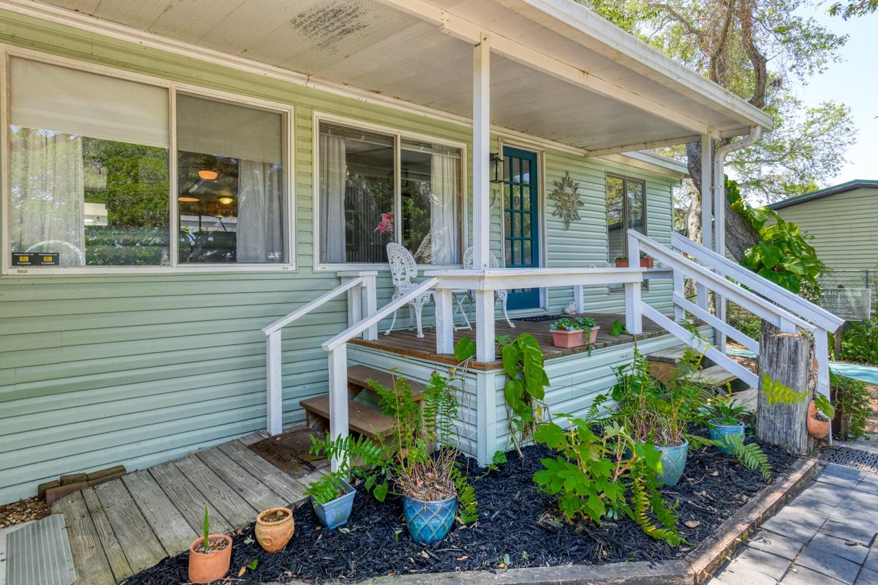 231 Hildago Road St. Augustine, FL 32080 - Photo 7 of 49 front a house with potted plants and a bench