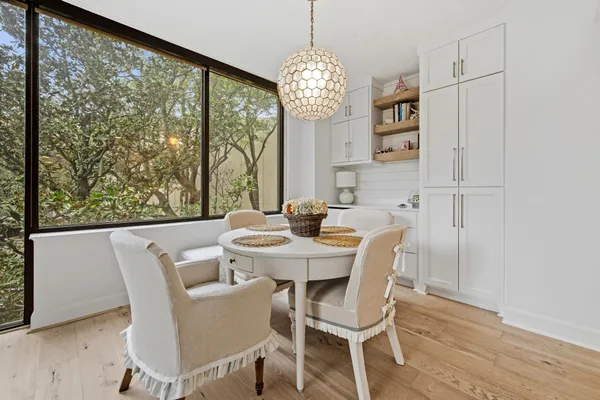 a view of a dining room with furniture a chandelier and wooden floor