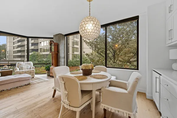 a dining room with furniture large windows and wooden floor