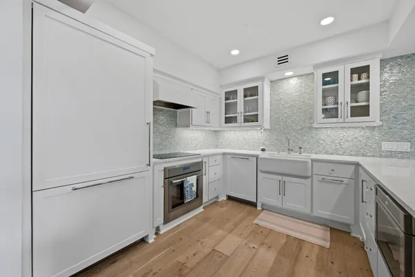 a kitchen with granite countertop white cabinets and white appliances