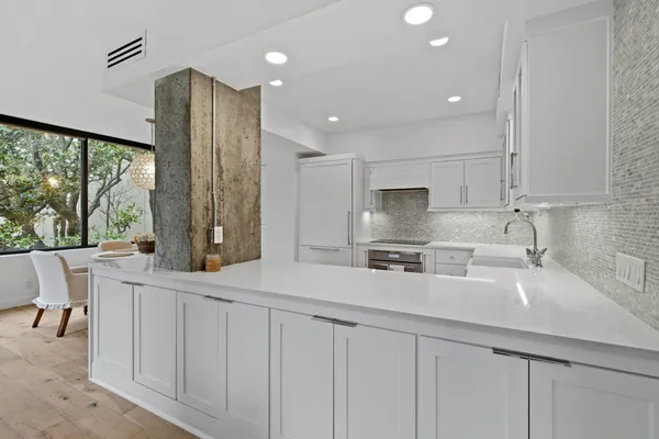 a kitchen with stainless steel appliances a sink a stove a refrigerator and cabinets