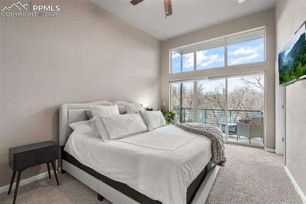 a large white bed sitting in a bedroom next to a window