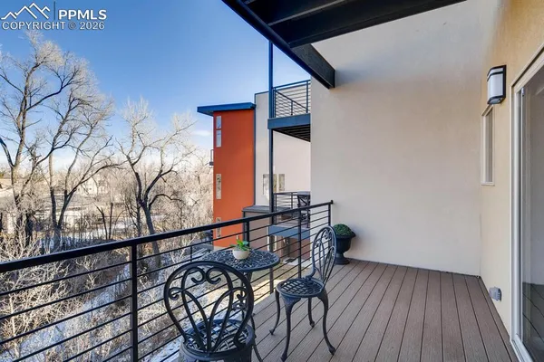 a view of a balcony with chairs and wooden floor