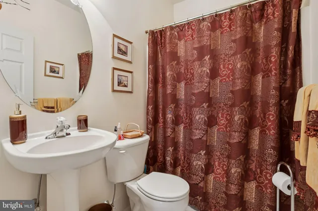 a bathroom with a toilet sink and mirror