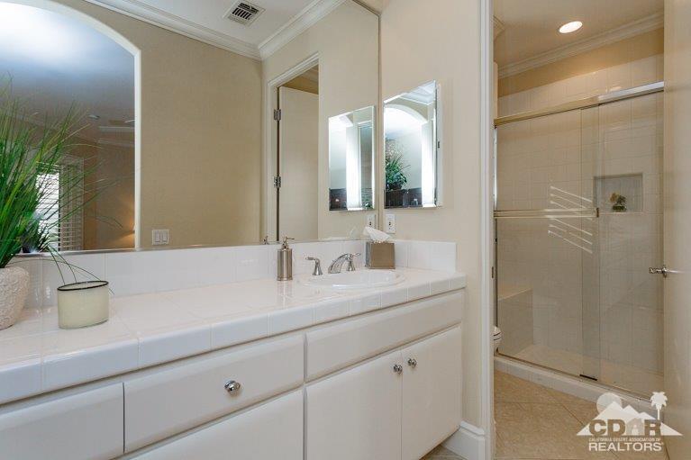 265 Loch Lomond Road Rancho Mirage, CA 92270 - Photo 30 of 46 a bathroom with a granite countertop sink a toilet a mirror and shower