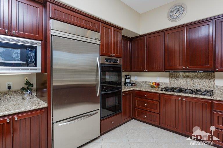 265 Loch Lomond Road Rancho Mirage, CA 92270 - Photo 10 of 46 a kitchen with granite countertop stainless steel appliances and wooden cabinets