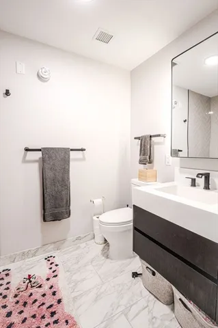 a bathroom with a sink a toilet and mirror