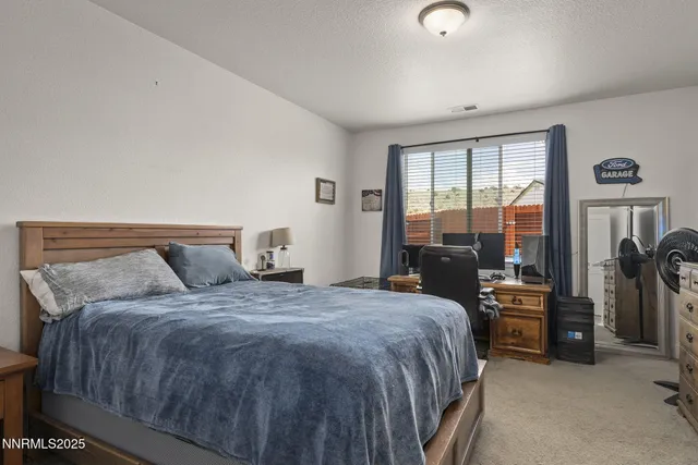 a bedroom with a bed and large windows