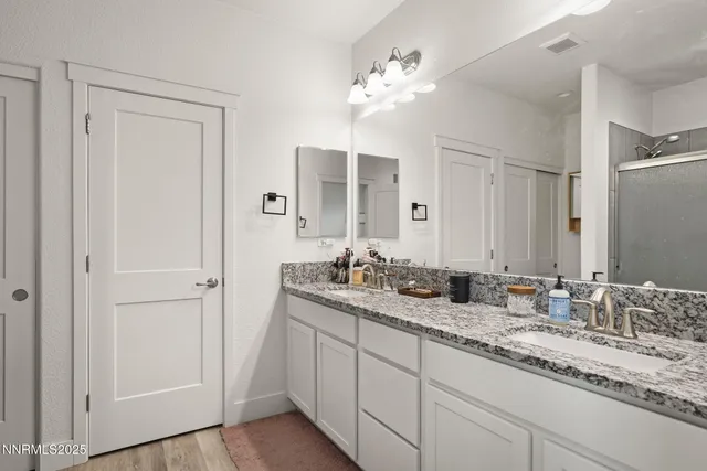a bathroom with a double vanity sink and mirror