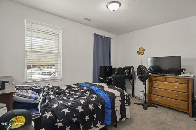 a bedroom with a bed and flat screen tv