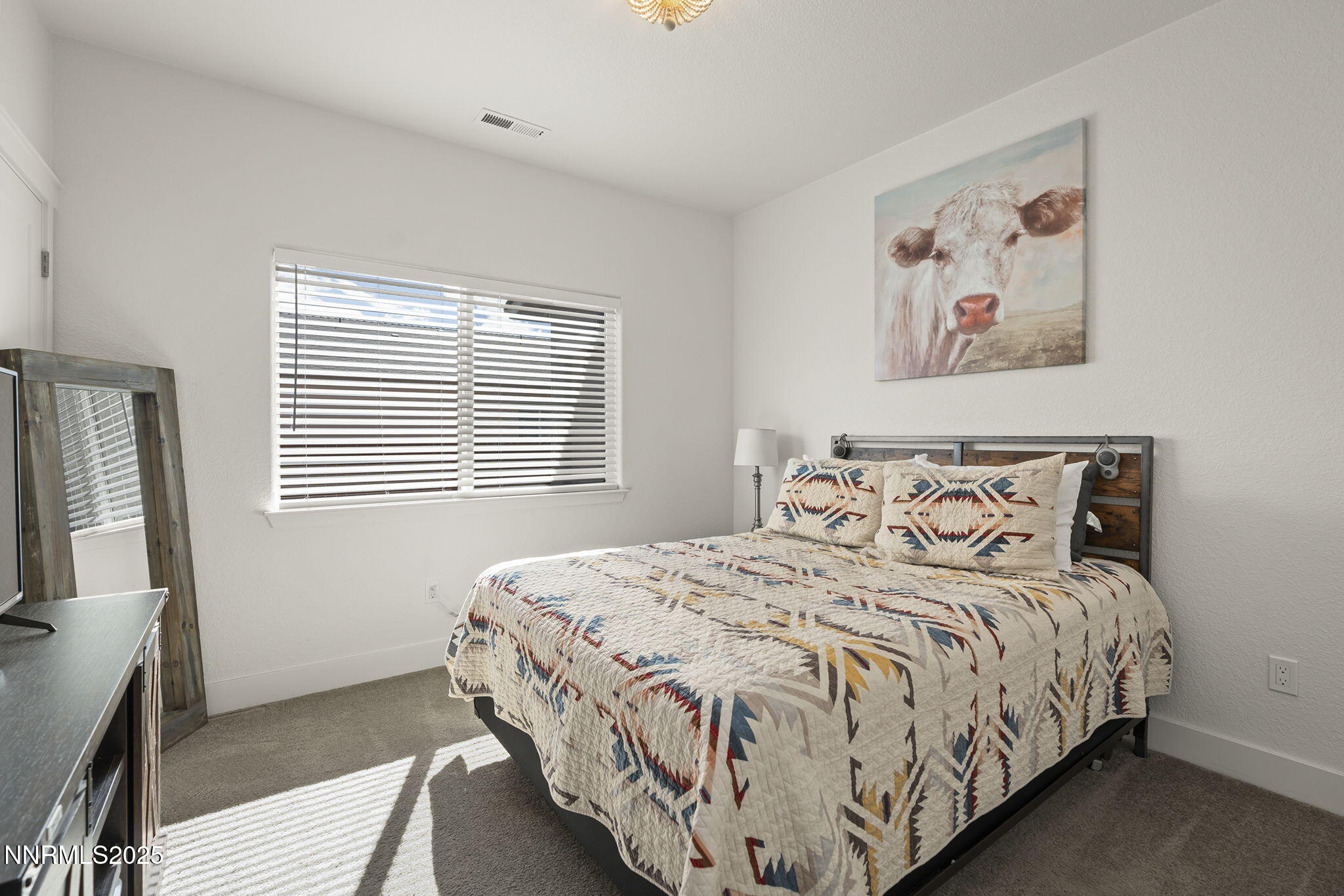 19064 Bronco Crk Court Reno, NV 89508 - Photo 16 of 20 a bedroom with a bed and a flat tv screen on a dresser