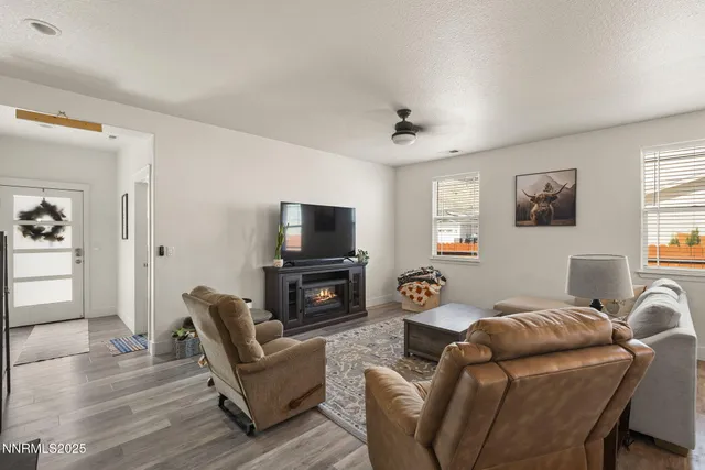 a living room with furniture a flat screen tv and kitchen view