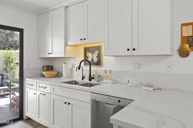 a kitchen with stainless steel appliances granite countertop a sink and a white cabinets
