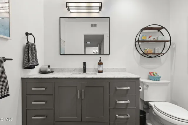 a bathroom with a toilet a sink and a mirror